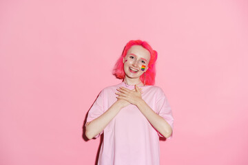 Young woman with rainbow makeup holding hands on her chest