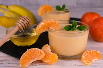 Tangerine honey smoothie in glasses.
Close-up.