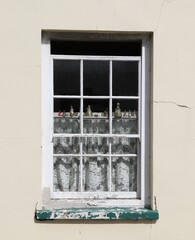 Old Window with Lace Curtains and Metal Figurines in Fishguard, Pembrokeshire, South Wales, UK