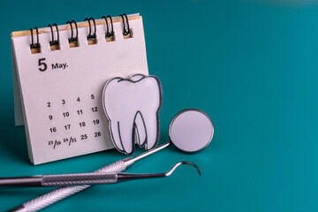 Dental instruments and calendars on blue background.Copy space.