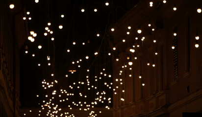 Fototapeta na wymiar A lot of lights hanged over a pedestrian street in the city center.