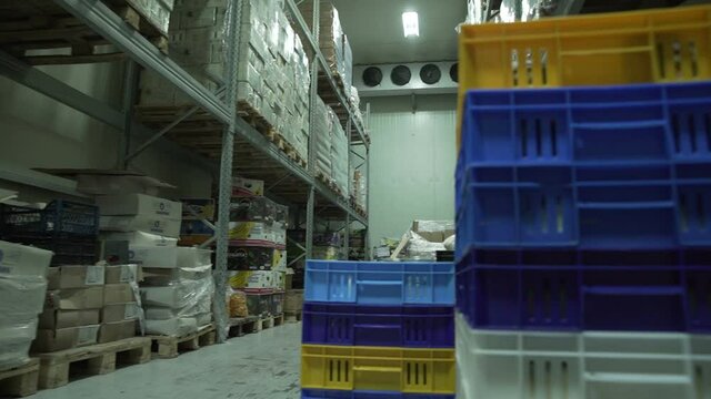 Yerevan, Armenia - September, 2021: Boxes of groceries in a industrial food large cold storage safety refrigerators. Panoramic shot. Slow Motion 