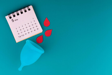 Menstrual cup and calendar on a blue background.