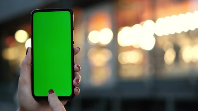 Point of View of voman at street Using Phone With Green Mock-up Screen Chroma Key Surfing Internet Watching Content Videos Blogs Tapping on Center Screen