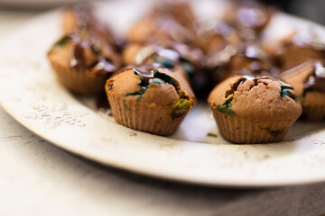 Christmas muffins with melted m&m and chocolate inside served on a Christmas plate with very nice bokeh