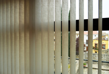 Cortinas de lamas verticales de tela para graduar la luz ambiental de las ventanas de una casa....