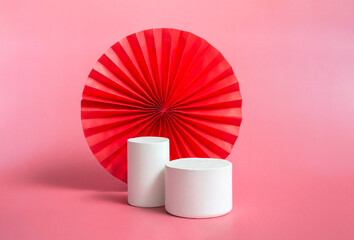 White podium display with red paper art fan background for branding and product presentation....