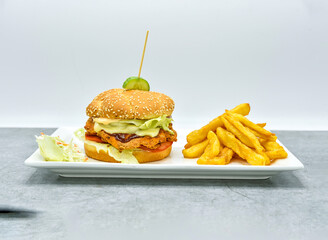 Fresh crispy chicken burger with cheese, tomatoes and lettuce on wood table, American fast food.