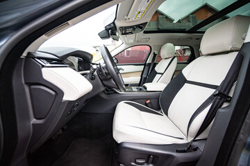 Modern luxury prestige car interior, dashboard, steering wheel. Orange red car interior.