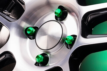 beautiful bright automotive wheel heptahedral nuts green close-up on a sporty style alloy wheel on...