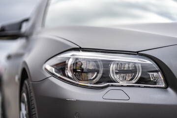 Obraz na płótnie Canvas headlight front of modern prestigious car closeup
