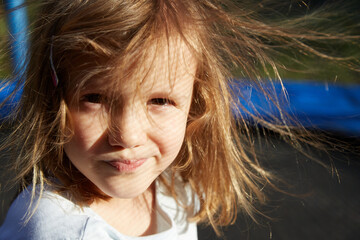 dziewczynka z rozwianymi włosami na trampolinie - obrazy, fototapety, plakaty
