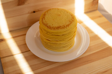 High stack of home-made pancakes on white plate. Breakfast for the whole family