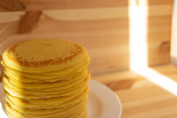 High stack of home-made pancakes on white plate. Breakfast for the whole family