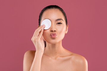 Happy korean woman cleansing her eyes with cotton pad © Prostock-studio