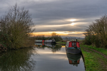 Canal and towpath with winter clouds and sun in the background