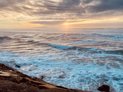Sunset cloudy sky rough sea and rocks in Cortegaca Portugal