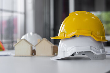 Yellow hard hat on desk work spec for engineering design , Safety helmet engineer, Background for building construction real estate