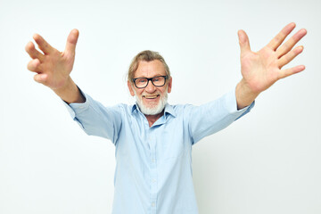 Photo of retired old man in blue shirts gestures with his hands isolated background