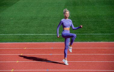 Obraz premium lady jumping in fitness sportswear. warm up on outdoor arena. training and workout. athletic female coach. woman sport trainer. healthy sporty lifestyle. health and energy. dieting