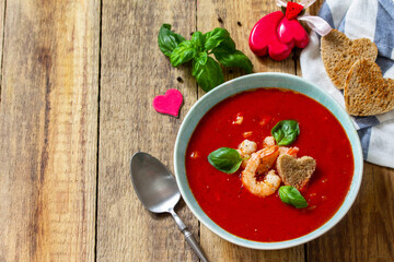 Homemade Valentine soup, festive food. Tomato soup puree gazpacho with tomatoes served seafood on a rustic wooden table. Copy space.