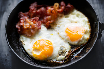pan of bacon fat  fried eggs breakfast