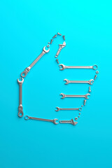 A symbolic thumbs-up sign made of wrenches, bolts and nuts on a blue background. Creative template for a high-quality engineering, construction and maintenance service. 3D render.