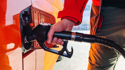 Man's hand filling the tank of his vehicle with the gas station hose