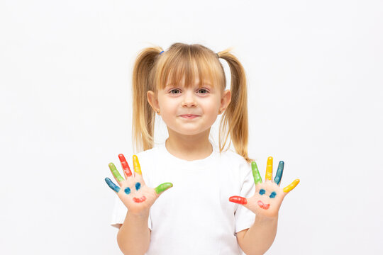 Happy cute little girl with colorful painted hands isolated on a white education concept