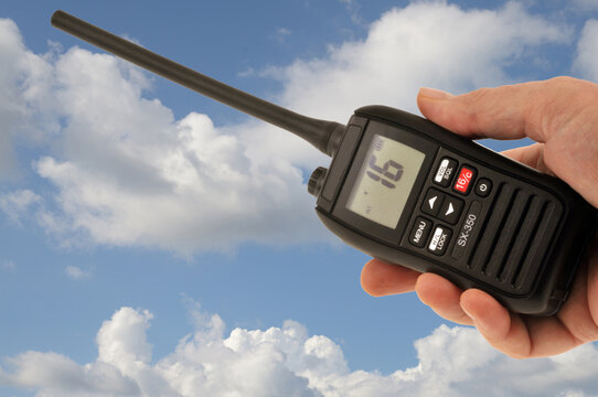 VHF en main en gros plan sur fond de ciel nuageux