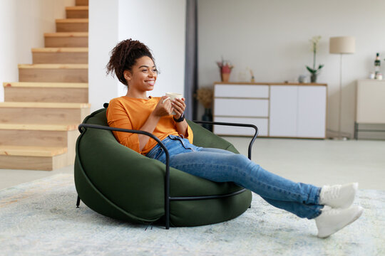 Calm Black Woman Having Rest At Home Drinking Coffee