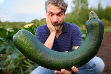 A man holds zucchini in his hands.
