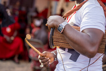selective focus of african man holding musical instrument in his arm, close up of local drum and a...