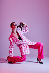 Portrait of beautiful young woman luxury clothing fashion plaid blazer pink background unaltered