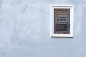 Old  blue concrete wall and closed windows. Vintage wooden window on the wall.