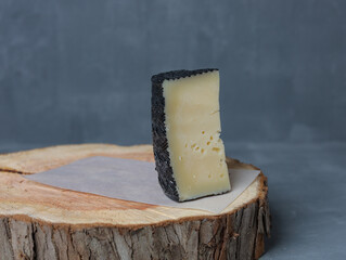 cheese on a wooden stand with paper on a gray background - 478158971