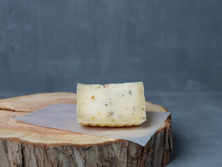 cheese on a wooden stand with paper on a gray background - 478159125