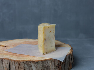 cheese on a wooden stand with paper on a gray background - 478159170