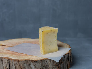 cheese on a wooden stand with paper on a gray background - 478159188