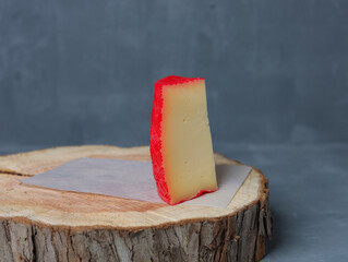 cheese on a wooden stand with paper on a gray background - 478159338