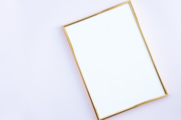 Empty frame on gentle pink background. A golden photo fra,e lying on background with place for your text. Mock up.