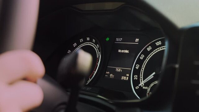 Green arrow shows flashing left turn on dashboard of contemporary automobile being driven by person extreme close view slow motion