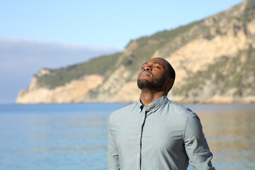Casual man with black skin breathing fresh air on the beach
