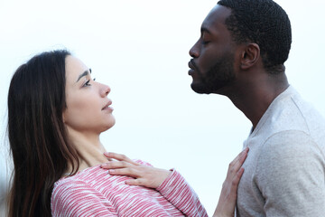 Woman rejecting a kiss from a man with black skin