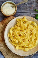 Italian food . Fresh home made  tagliatelle vegetarian  egg pasta  with ,parmesan cheese ,fresh parsley  and black pepper.Pasta cacio e pepe