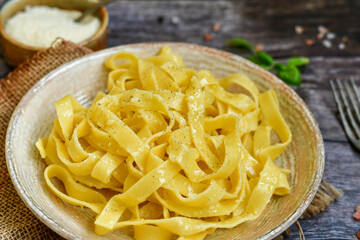 Italian food . Fresh home made  tagliatelle vegetarian  egg pasta  with ,parmesan cheese ,fresh parsley  and black pepper.Pasta cacio e pepe