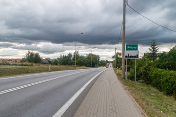 Fototapeta na wymiar Street and entrance street sign of Rozyny, Poland.