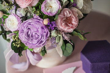 Beautiful spring bouquet in pink and purpl color, in round ceramic vase. Arrangement with Peonies roses. Decorative flowers in a round vase.