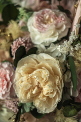 Beautiful preserved flower bouquet in ceramic vase on white table. Stylish bouquet in peach tones closeup.