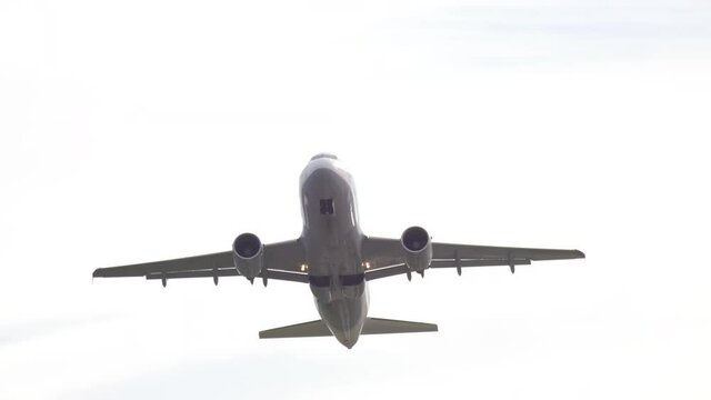 Overhead aircraft retracts landing gear and gains altitude. Airliner flies away